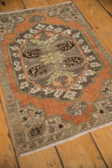 Pale rust and silver distressed Oushak rug displaying unique floral motifs and wear.