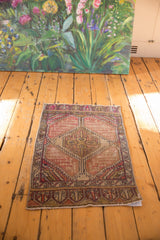 Distressed Oushak rug mat with geometric medallion and muted aubergine, ivory, mauve palette.