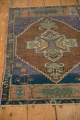 Distressed hand knotted Oushak rug detail showing serrated medallion in chocolate brown, muted purple, and aqua.