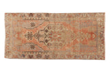 Distressed vintage Turkish Oushak rug runner with faded blush, beige, and silver floral medallion.