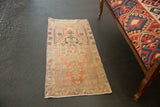 Distressed Oushak rug detail with faded floral pinwheel motifs in blush and ivory.
