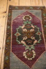 Distressed aubergine central medallion with stylized Rococo palmette florals.