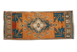 Distressed vintage Oushak runner with pale rust terra cotta, navy blue quatrefoil medallion, geometric corners.