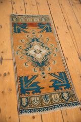 Distressed corner of the vintage Oushak rug, featuring navy and rust serrated geometric patterns.