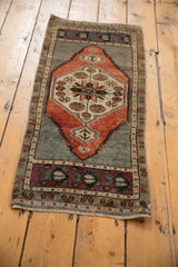 Vintage distressed Oushak rug corner with pale brick, silver, aubergine floral patterns, and worn texture.