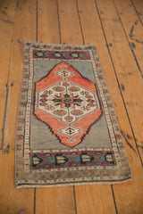 Detail of vintage distressed Oushak rug showing floral pinwheels and aubergine border.