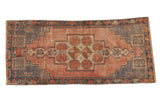Distressed Oushak runner, geometric medallion, pinwheel motifs, dusty mauve and slate blue.