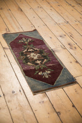 Vintage Oushak rug showing distressed aubergine pile, palmettes, and visible foundation.