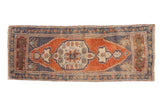 Distressed Oushak runner showcasing pale rust field, roundel medallion, and dusty blue borders.