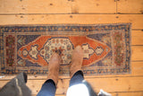 Distressed Oushak rug's pale rust roundel medallion and dusty blue field texture.