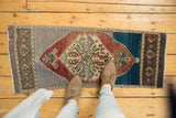 Distressed Oushak rug corner with abrashed mauve spandrel, wine red, mint green motifs.