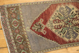 Distressed vintage Oushak rug with abrashed field, faded wine red and geometric detail.