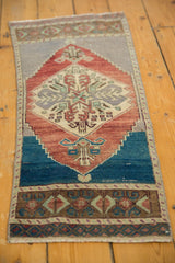 Distressed vintage runner showing worn texture, faded red-blue palette, and bowed edges.
