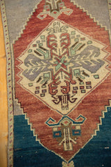 Distressed vintage Oushak rug with abrashed indigo, mauve, and geometric medallion detail.