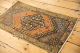 Distressed vintage Oushak rug texture with even wear, tangerine, gold, and charcoal geometric patterns.