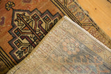 Distressed tangerine and gold Oushak rug pile, showing secure edge and hand-knotted foundation.