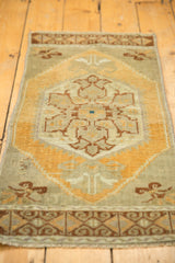 Worn pile and woven side edge of a vintage distressed Oushak rug with pale orange floral motifs.