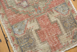 Distressed Oushak rug texture with even wear, dusty rose, ivory, and grey.