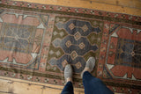 Muted blush, denim blue, and bronze geometric patterns with abrash on this distressed Oushak runner.