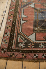 Geometric dark chocolate border with primitive motifs on a distressed blush Oushak runner.