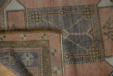 Oushak runner corner showcasing short pile, dark fringe, and time-softened geometric pattern.