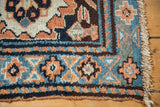 Rust, navy, and blue geometric borders on the hand-knotted corner of an antique Kurdish bagface.