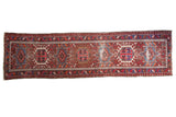 Vintage Karaja runner, cherry red field, geometric medallions, blue accents, visible wear, 2'3