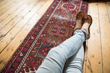 Vintage Karaja runner featuring repeating geometric medallions and vivid cherry red, sky blue patterns.
