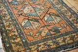 Hand-knotted Heriz rug pile showing oversized plant motifs in madder, blue, sand.