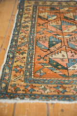 Vintage Heriz rug corner with geometric germinating plant motifs, blush, and mallard green.