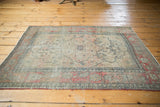 Faded cochineal raspberry red Kerman rug border, delicate floral vinery, and light tatter.