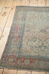 Faded cochineal red border with delicate vinery and light tatter on antique Kerman rug.