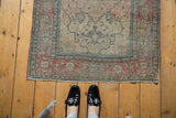 Antique Kerman rug with faded cochineal red border, floral field, and mostly even wear.