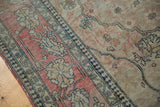 Antique Kerman rug section: dark navy border, aged ivory, faded cochineal red field, mostly even wear.