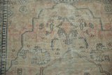 Softened pile and delicate navy vinery on this antique Kerman rug's faded field.