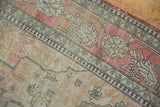 Delicate navy vinery and faded cochineal raspberry red field on an antique Kerman rug section.