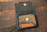 Textured leather interior and metal snap closure of the open rug fragment coin purse.