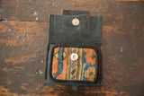Open leather coin purse interior showcasing rug fragment's orange, blue geometric design and snap.