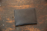Dark brown pebbled leather exterior of the coin purse with neat stitching.