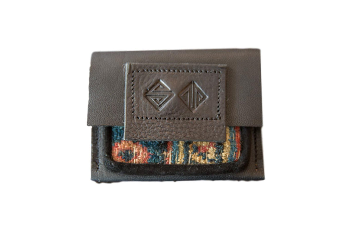 Dark brown leather coin purse featuring a colorful, woven vintage rug fragment accent.