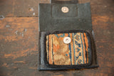 The coin purse's interior with a woven rug panel and silver magnetic snap closure.