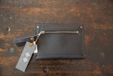 Exterior zip pocket and brand tag on the back of the handmade black leather wallet.