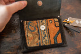 Rug Fragment Coin Purse open to reveal orange and blue geometric pattern and magnetic snap.