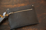 Coin purse back: dark textured leather with metal zipper and brown tassel.