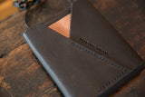 Debossed Swag and Tassel brand name and stitch line on the black leather bag flap.