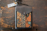 Handcrafted black leather and rug fragment shoulder bag with orange and blue pattern.