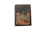 Leather shoulder bag with unique rug fragment, vibrant orange and blue geometric design.