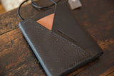 Black vegetable tanned leather bag flap with Swag and Tassel embossing and tan accent.