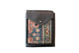 Unique geometric rug fragment and dark leather shoulder bag, 5.5x7 inches.