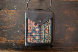 Rug Fragment and Leather Shoulder Bag with red, blue, beige geometric pattern and metal snap.